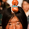 Head Piece Photo: Traditional Tibetans with unique head ornamentation walk the Barkhor. 