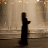 Water Works Photo: A female Arab tourist walks in front of a fountain at Kuala Lumpur City Center (KLCC).