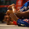 Muay Thai Action Photo: Entangled muay thai kickboxers fall to the canvas ending up in awkward positions.
