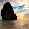 Railay Beach Mountain Photo: A gentle waves breaks on the shore at sunset in front of a large limestone mountain on Phranong Beach.