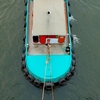 Tugboat Shipping Barge Photo: A tugboat lumbers up-river, seen from a top-down perspective on the Chao Phraya river in Bangkok.
