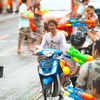 Songkran Bus Assault Photo: Innocent motorcyclists are caught in the crossfire of a watery battle with a bus during Songkran water festival.